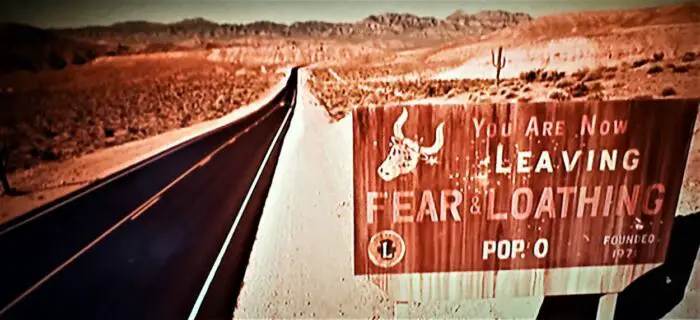 Exit sign with cattle skull painted on it and the message, "You are now leaving Fear and Loathing." Seen in Fear and Loathing in Las Vegas (1998)