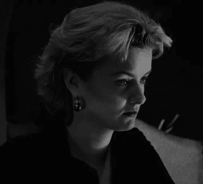 Screenshot from the movie Following showing a woman in a dark bar. 