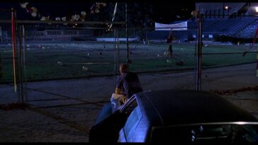 Preston Meyer sits on his car and looks out onto the football field in Can't Hardly Wait.