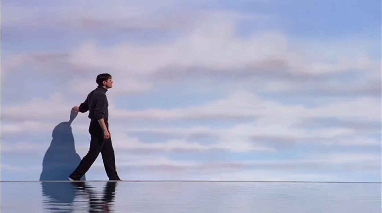 Truman walks in front of a wall painted like the sky at the end of The Truman Show