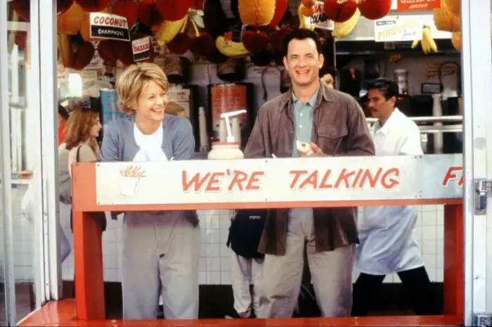 Meg Ryan and Tom Hanks above a banner reading "We're Talking."