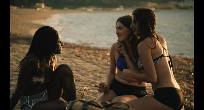 Image from Homecoming: Jessica (Ester Gohourou) hangs out with her new girlfriend Gaia (Lomane de Deitrich) and her friend at the beach