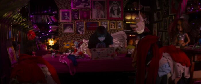 Dorothy sits hunched over her laptop in her pink room