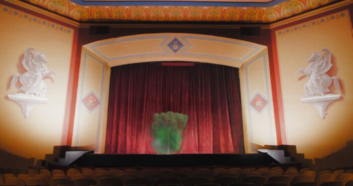 Mysterious green smoke invades the red-curtained theatre in Lynch-Oz