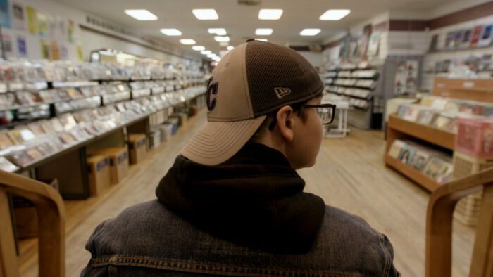 Sav Rodgers looks through various items in a record store.