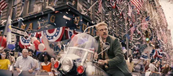 A man searches for his man on a motorcycle during a parade in Indiana Jones and the Dial of Destiny.