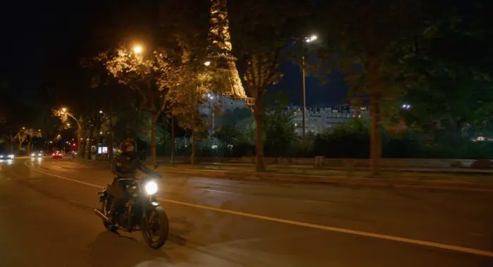 Mia rides her motorcycle at night. 