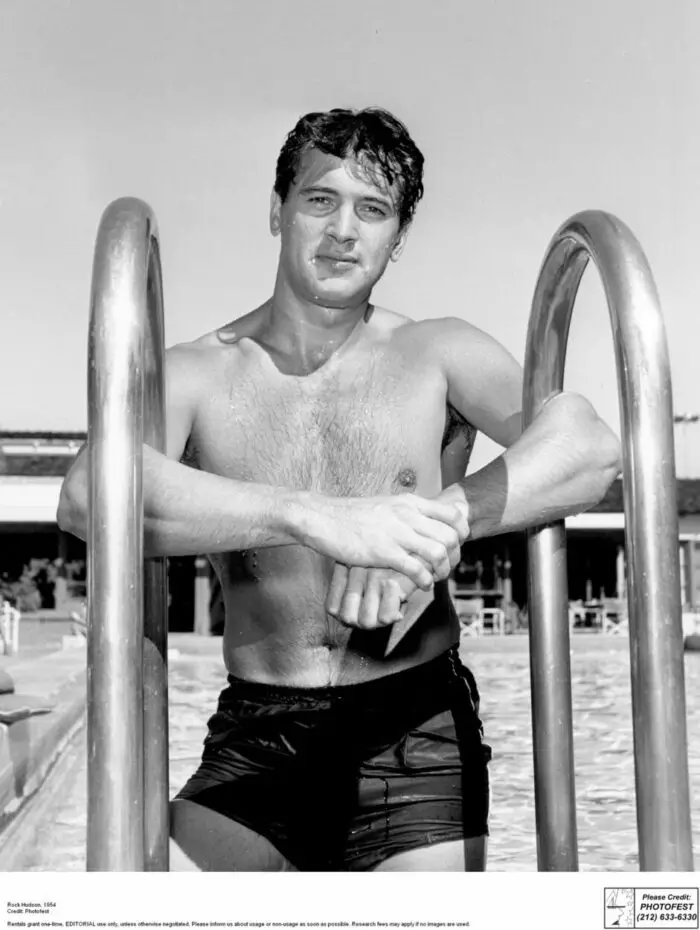 Rock Hudson poses on the steps of a swimming pool in 1954.