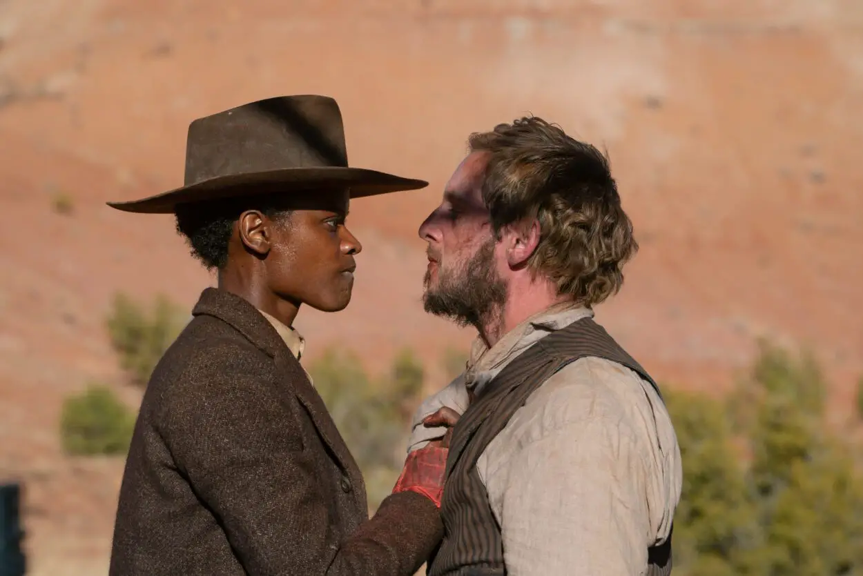 Still from SURROUNDED showing Letitia Wright's Mo Washington and Jamie Bell's Tommy Walsh. Washington holds Walsh by the collar and the two angrily stare each other down. 