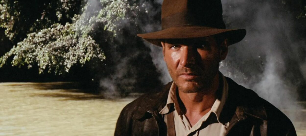 Indiana Jones steps forward from canopy shadows in Raiders of the Lost Ark