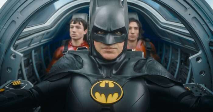 Batman (Michael Keaton) flies his Batplane with two versions of Barry Allen in the back seats.