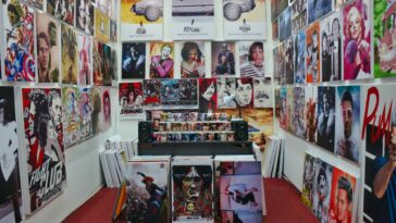 A room is decorated in movie paintings and portraits.
