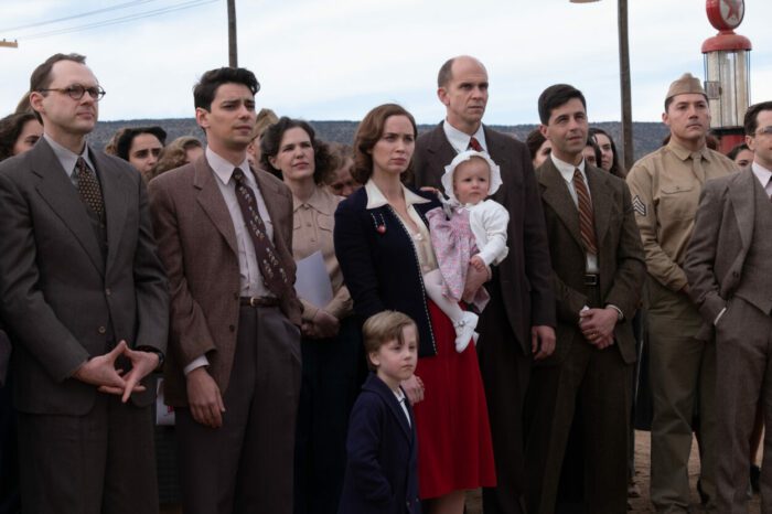 Front Row L to R: Christopher Denham as Klaus Fuchs, Seth Neddermeyer is Devon Bostick, Emily Blunt is Kitty Oppenheimer, Gustaf Skarsgård is Hans Bethe, and Josh Peck is Kenneth Bainbridge in OPPENHEIMER, written, produced, and directed by Christopher Nolan. © Universal Pictures. All Rights Reserved.