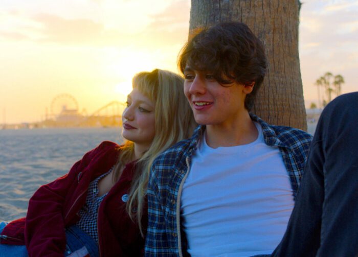 Two teens sit at sunset on a beach in Tiger Within