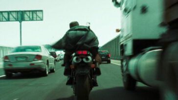 Trinity and the Keymaker ride a motorcycle on a freeway in The Matrix Reloaded