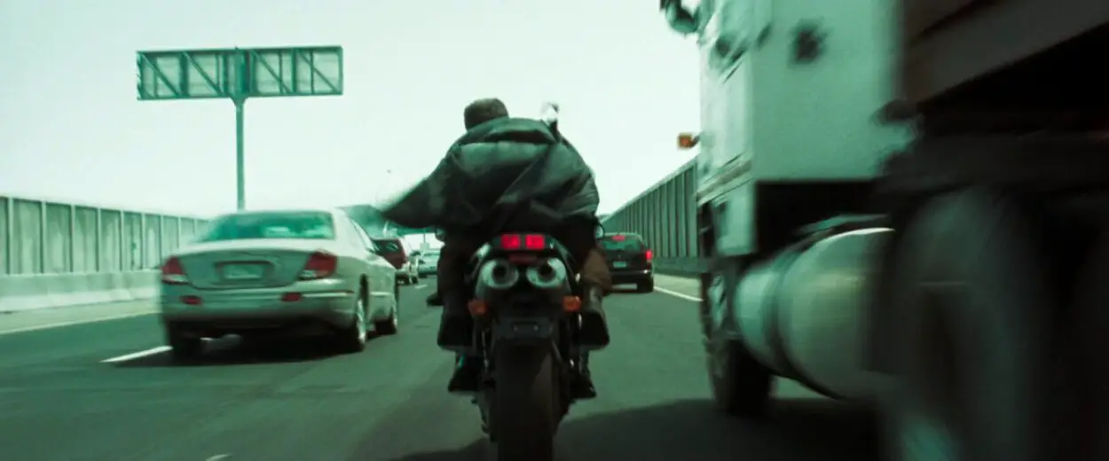 Trinity and the Keymaker ride a motorcycle on a freeway in The Matrix Reloaded