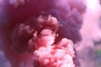 A smoke bomb lets out pink smoke.