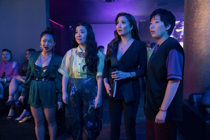 Four well-dressed ladies look over a nightclub scene.