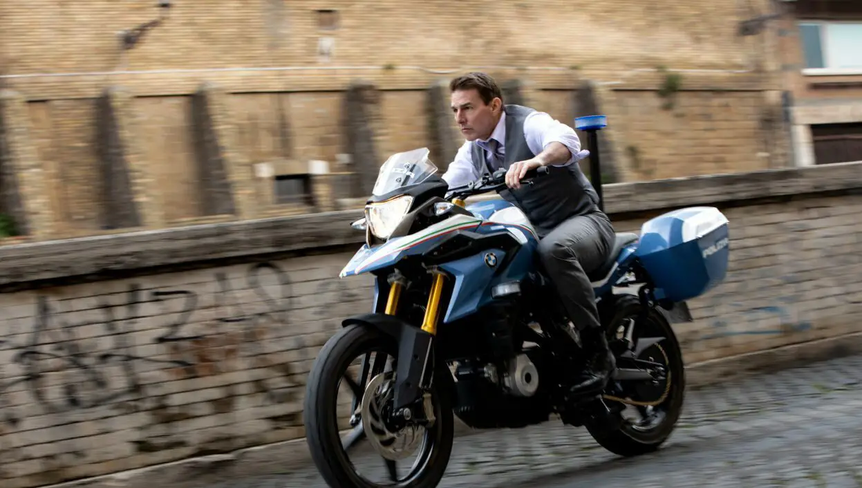 A man in a shirt and tie speeds down a street on a police motorcycle in Mission: Impossible - Dead Reckoning Part One