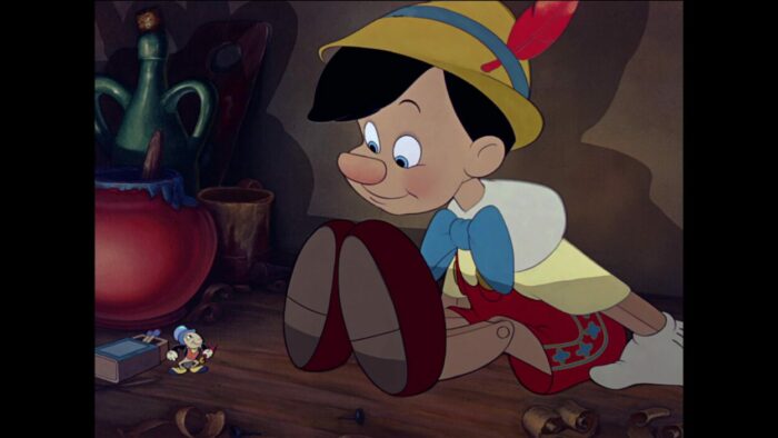 Pinocchio and Jiminy Cricket look at each other for the first time.