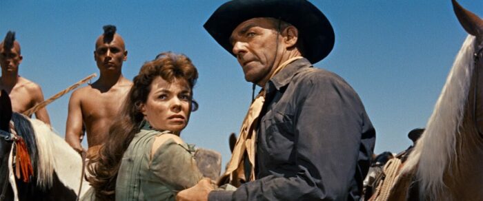 A Western sheriff grabs a woman by the arm.
