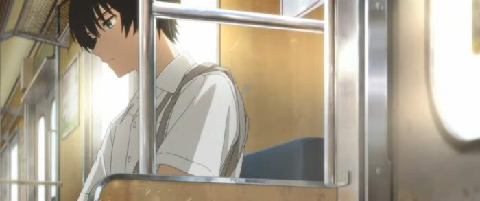 An image of a boy in anime looking out a window.