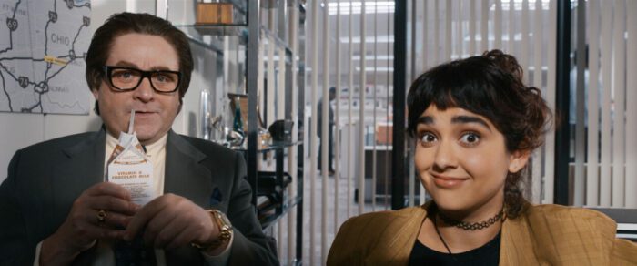 Maya (Geraldine Viswanathan) and Ty (Zach Galifianakis) stare into a computer screen as they experience the internet for the first time.