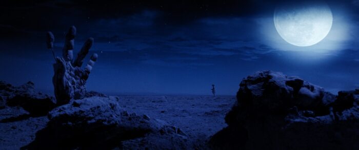 A blue-tinted landscape with a large moon.