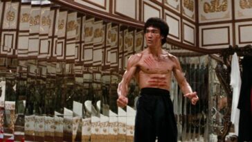 A man cut and shirtless flexes for battle in Enter the Dragon