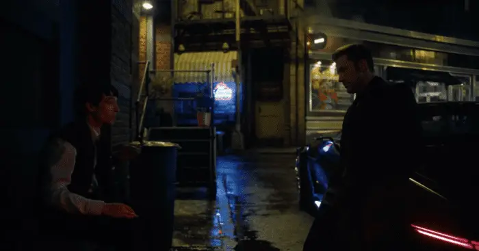 Barry Allen (Ezra Miller) talks with Bruce Wayne (Ben Affleck) in a dark alleyway about how trauma shapes heroism