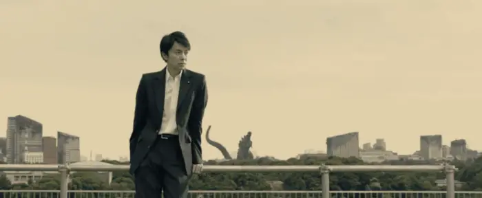 Hiroki Hasegawa as Rando Yaguchi in Shin Godzilla, with the frozen Godzila in the background