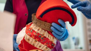 A Sámi artifact being handled with gloves