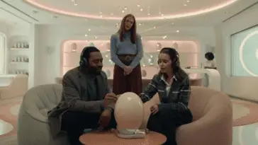 Two parents listen to a pregnancy pod next to a client manager in The Pod Generation