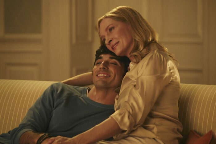 Alex's mom (Uma Thurman) hugs him on the couch in a touching coming out scene. 