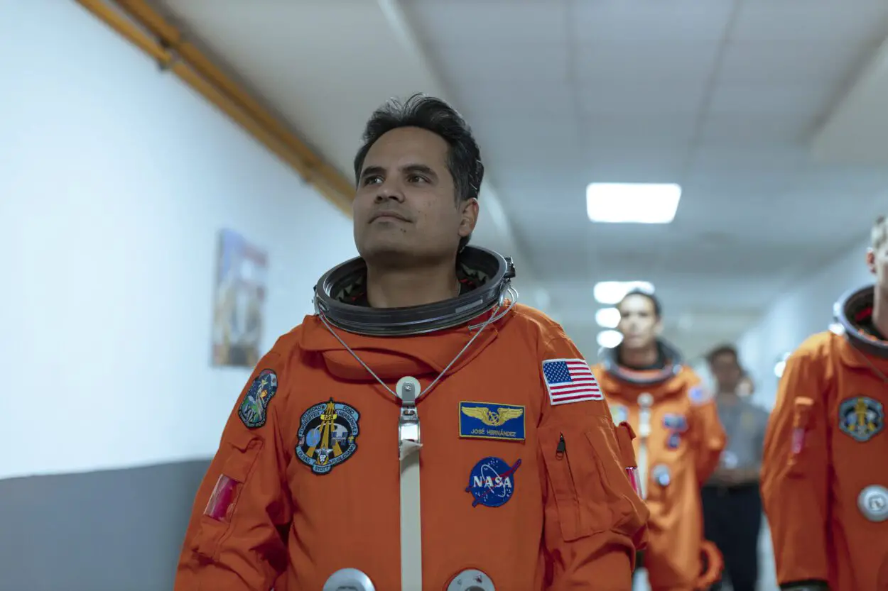 A man in an astronaut uniform walks down a corridor in A Million Miles Away