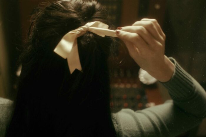Agnes unties the ribbon from her hair.