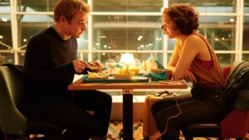 Hadley and Oliver sitting in the airport eating in Netflix's Love at First Sight