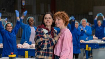 Joanne and Helen embrace on the factory floor