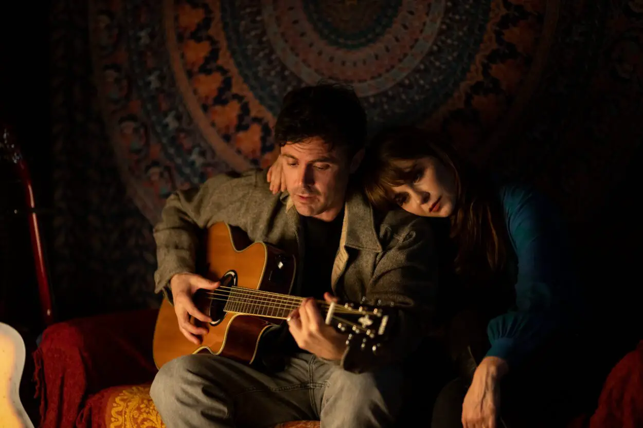 A wife rests her head on her husband playing guitar in Dreamin' Wild
