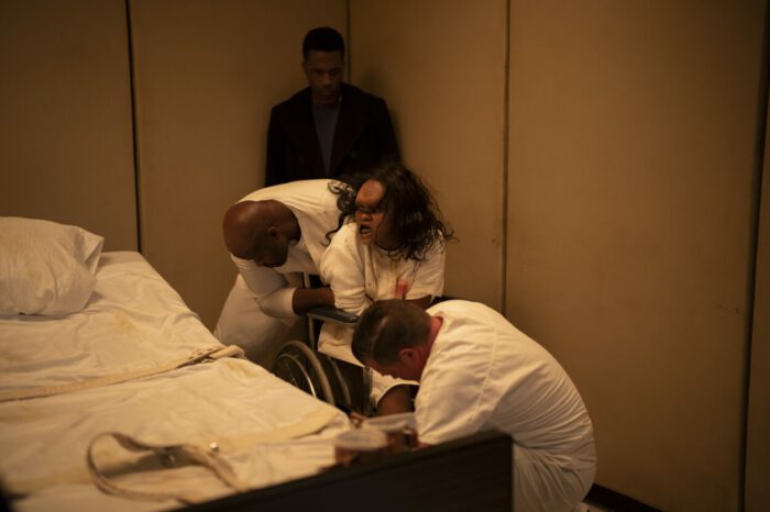 (from left) Victor Fielding (Leslie Odom, Jr., background) and Angela Fielding (Lidya Jewett) with additional cast members in The Exorcist: Believer, directed by David Gordon Green.
