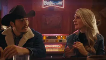 Lily Rabe as Julia sits with Henry Golding as Vance in a bar in Downtown Owl. Photo: Sony Pictures.