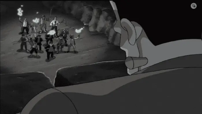 Frankenstein's monster overlooks an angry mob in a black and white scene.