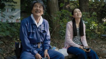 Hirayama (Koji Yakusho) and his niece Niko (Arisa Nakano) discuss photography on a park bench.