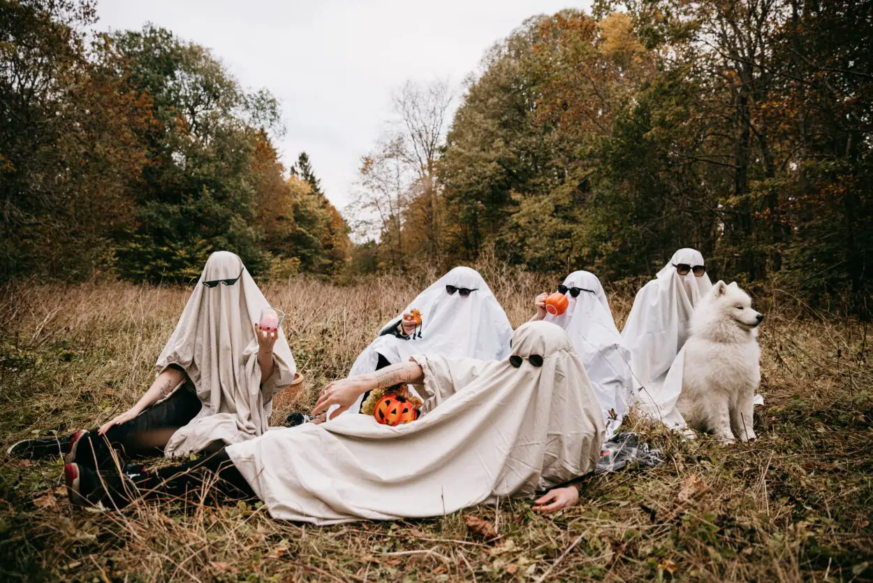 People in Halloween Ghost Costumes Sitting on Grass