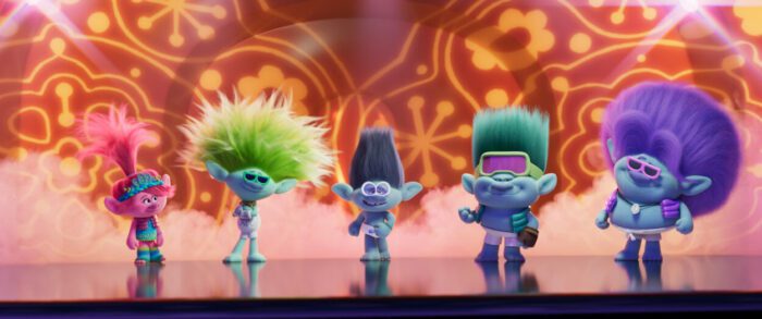 The five members of a troll band walk forward on a stage.