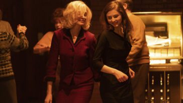 Still from EILEEN showing Rebecca (Anne Hathaway) and Eileen (Thomasin Mackenzie) dancing together in a bar.