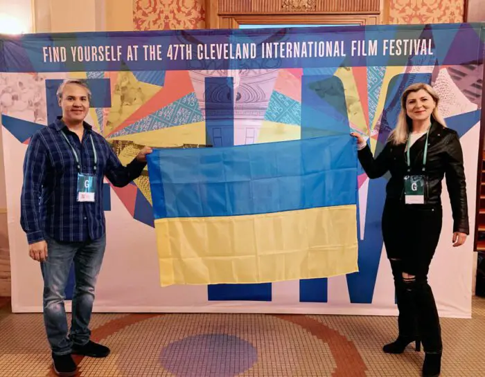 (L-R) TJ Collins and Lesya Kalynska raise the Ukrainian flag at the Cleveland International Film Festival in March, 2023. 