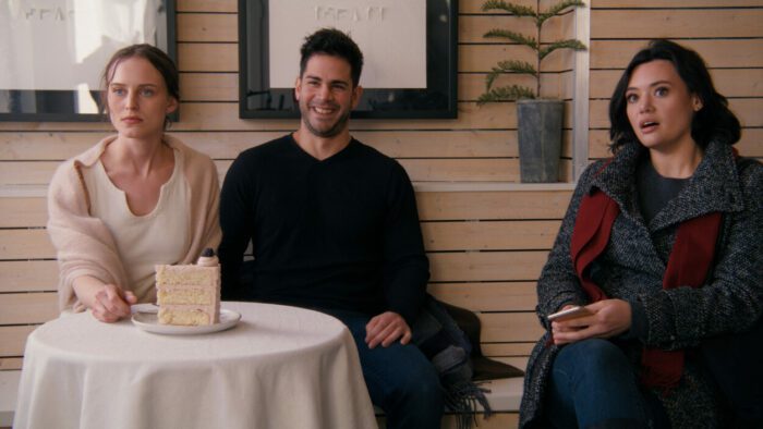 [L to R] India Chappell, Joe Piazza, and Rivkah Reyes as Heather, Mark, and Sue at a wedding cake tasting in A Holiday I Do (2023).