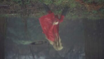 Upside down image of a little girl wearing a red mac