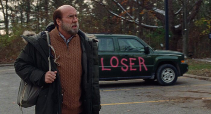 Paul looks with despair as his green car has been tagged with the word "LOSER" in pink paint. 